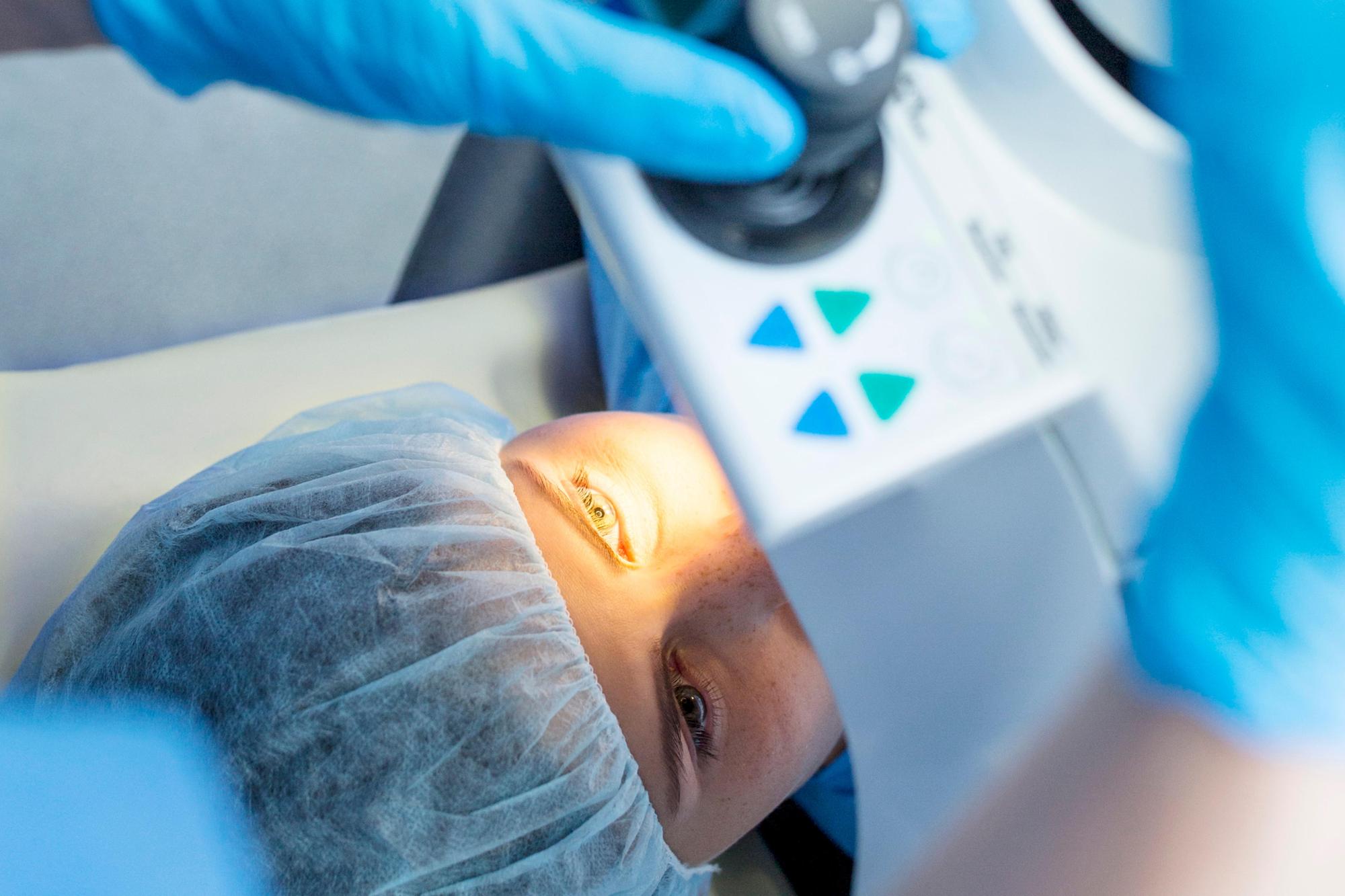 Chirurgien réalisant une opération LASIK au laser sur un patient allongé, clinique moderne en Tunisie