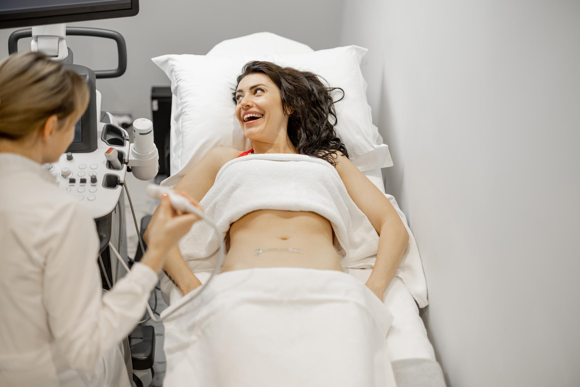 Woman lying on operating table during liposuction abdomen surgery in Tunisia clinic with medical team